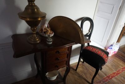 une petite table sur laquelle se trouvent une chaise et une lampe