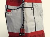 red and white backpack with the word mcq on it sitting on a white surface