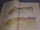 an open book on a table with a map of the world in it
