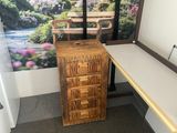 a desk with a drawer and a picture on the wall behind it