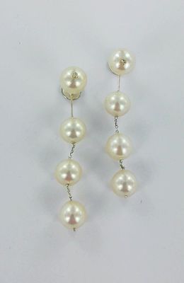 une paire de boucles d'oreilles en perles et diamants sur fond blanc