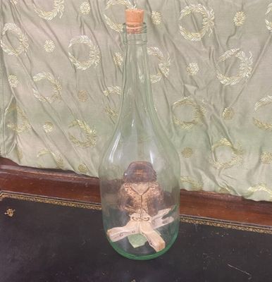 une bouteille en verre munie d'un bouchon en liège, dans laquelle se trouve un bouchon en liège