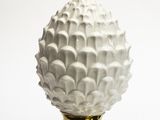 un vase blanc avec un socle doré sur fond blanc