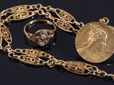 a close up of a gold necklace with a coin and a ring