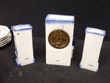 three small white and blue ceramic clocks on a table
