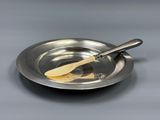 a silver plate with a wooden spoon in it