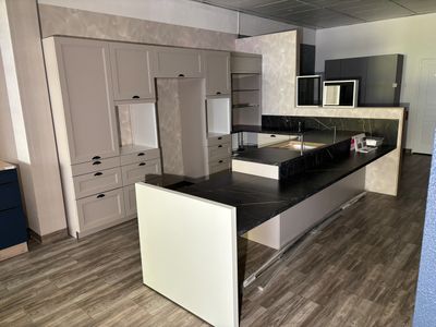 a kitchen with a black counter top and white cabinets