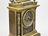 a gold clock with a bird on top of it