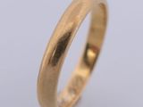 a gold wedding ring on a white background