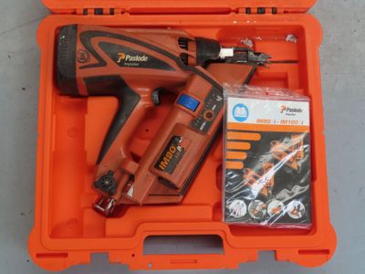 une boîte orange contenant une cloueuse sans fil et un outil