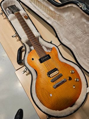 une guitare posée dans son étui, par terre