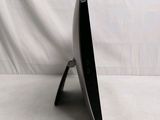 a black computer monitor sitting on a stand on a white surface
