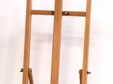 a wooden easel that is standing up against a white wall