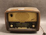 une radio à l'ancienne posée sur une table près d'un mur gris