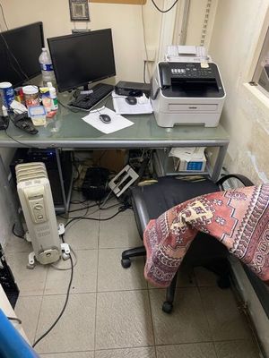 a desk with two computers and a printer on it