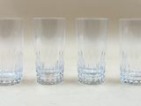 quatre verres transparents sont alignés sur un plan de travail