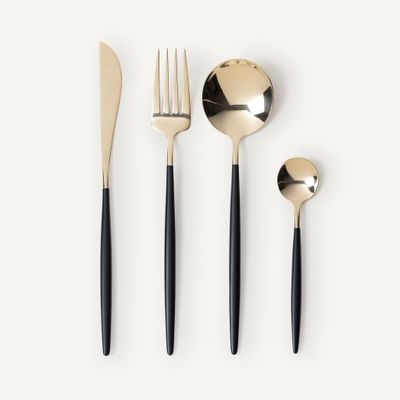 a set of black and gold flatware with a spoon, fork and spoon rest
