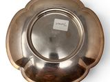 a silver plate on a white surface with a sticker on it