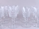 several clear wine glasses are lined up on a white surface