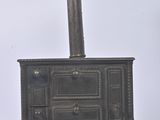 a metal stove with a chimney on top of it