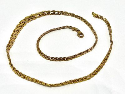 a close up of a gold chain on a white surface