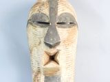 a wooden sculpture of a face with a cross on it