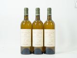 trois bouteilles de vin posées l'une à côté de l'autre sur une table