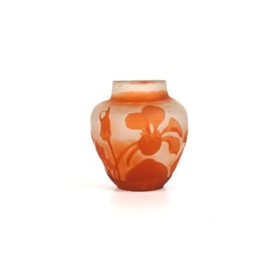 un vase orange orné d'un motif floral