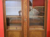 une photo d'une armoire en bois avec des portes vitrées dans une pièce