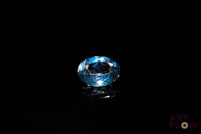 a close up of a blue diamond on a black surface