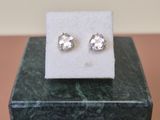 a close up of a pair of earrings sitting on top of a marble block