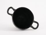 a black cup that is sitting on a white surface
