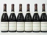 six bouteilles de vin sont alignées sur une table