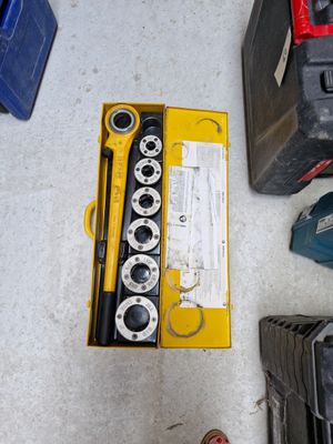 une boîte à outils posée par terre à côté d'une paire de chaussures