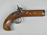 un vieux pistolet avec une poignée en bois sur une surface blanche
