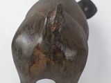 a small statue of a pig on a white surface