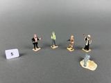 cinq figurines représentant des personnes debout en cercle