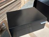 a black box sitting on top of a pile of boxes