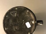 a small metal object on a table with a sticker on it