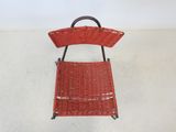 an image of a red wicker chair sitting on a white floor