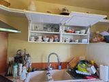 a kitchen with a sink and shelves above it