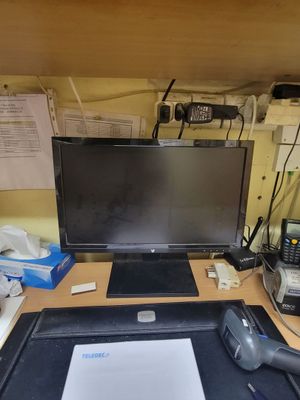 a desk with a monitor, mouse, and other items on it