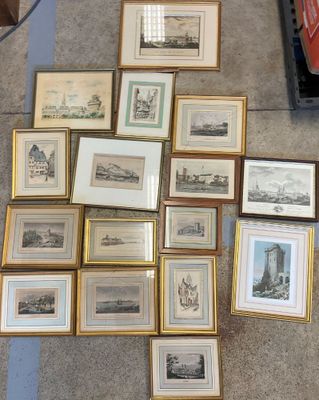 a lot of framed pictures on the floor of this room