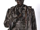 a bronze statue of a man holding a gun