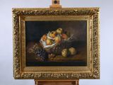 painting of a basket of fruit on an easel with grapes and peaches