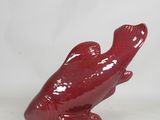 a red bird figurine sitting on top of a white table