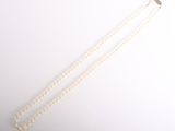 gros plan d'un collier de perles sur une surface blanche