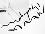 a black and white photo of a person writing on a piece of paper