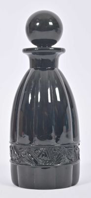 a black vase sitting on a white surface with a white background