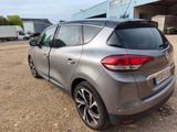 the rear end of a silver car parked in front of a building
